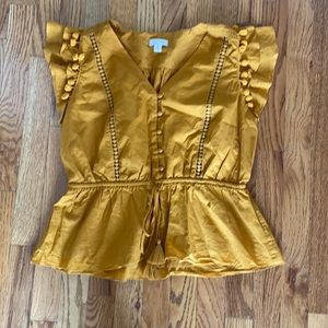 Mustard colored shirt with pom pom on flutter sleeve